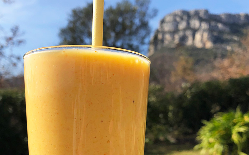 Solgul smoothie med et stort smil