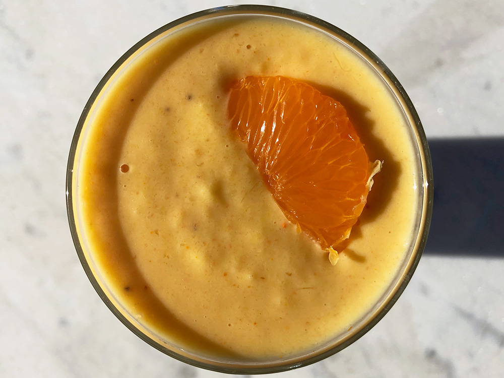 Solgul smoothie med et stort smil