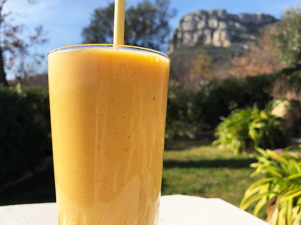 Solgul smoothie med et stort smil