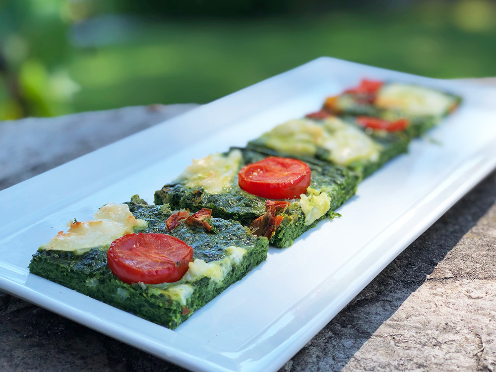 Lett quiche uten bunn med spinat, chevre og tomater