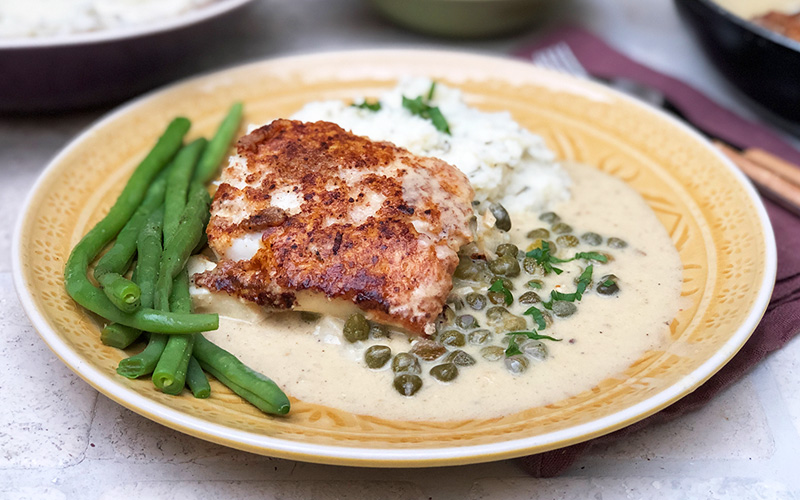 Torsk i piccatasaus på en seng av blomkålmos