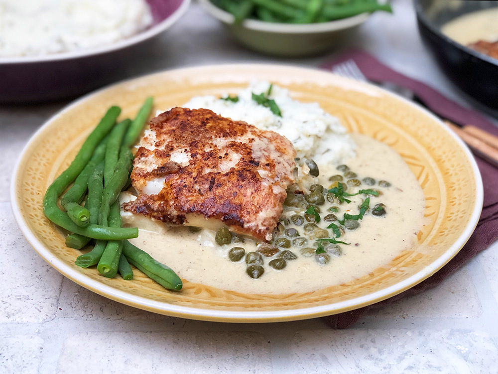 Torsk i piccatasaus på en seng av blomkålmos