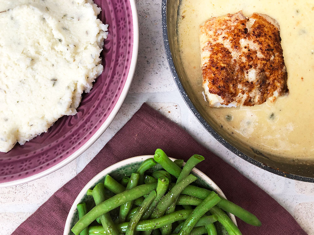 Torsk i piccatasaus på en seng av blomkålmos